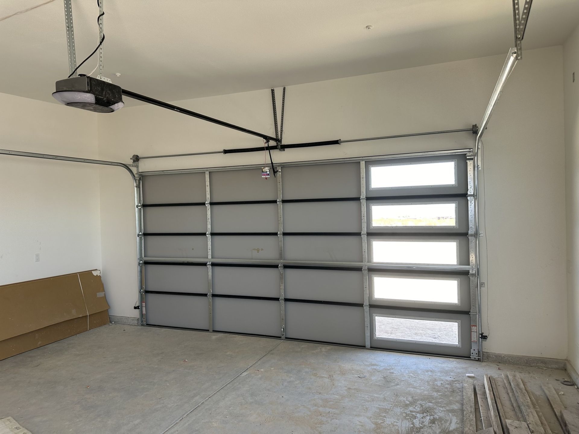 An empty garage with a garage door open and a garage door opener