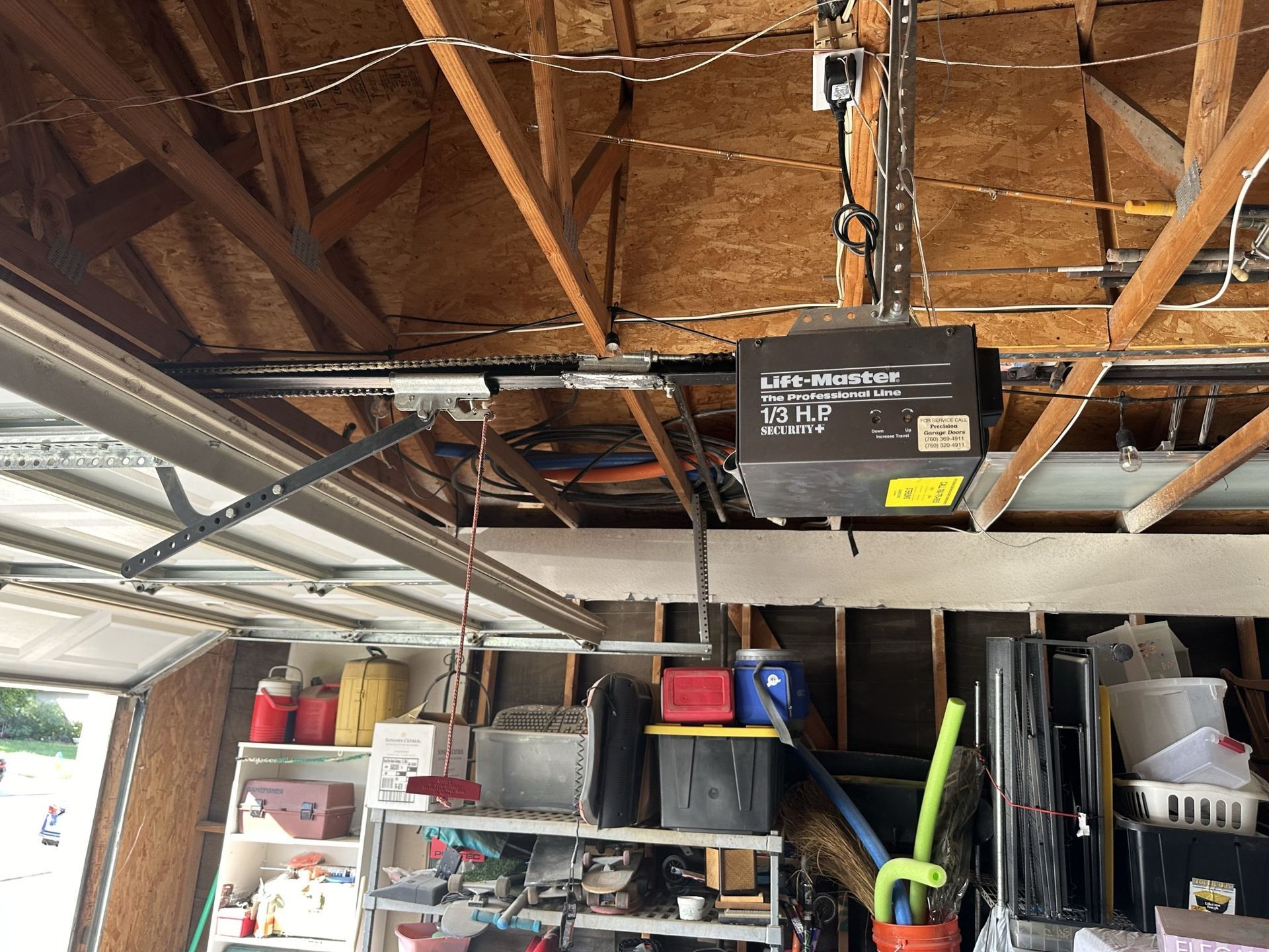 A garage door opener is hanging from the ceiling of a garage.
