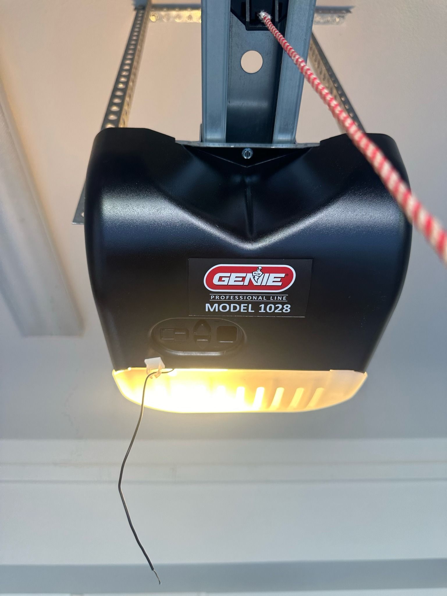A black garage door opener is hanging from the ceiling