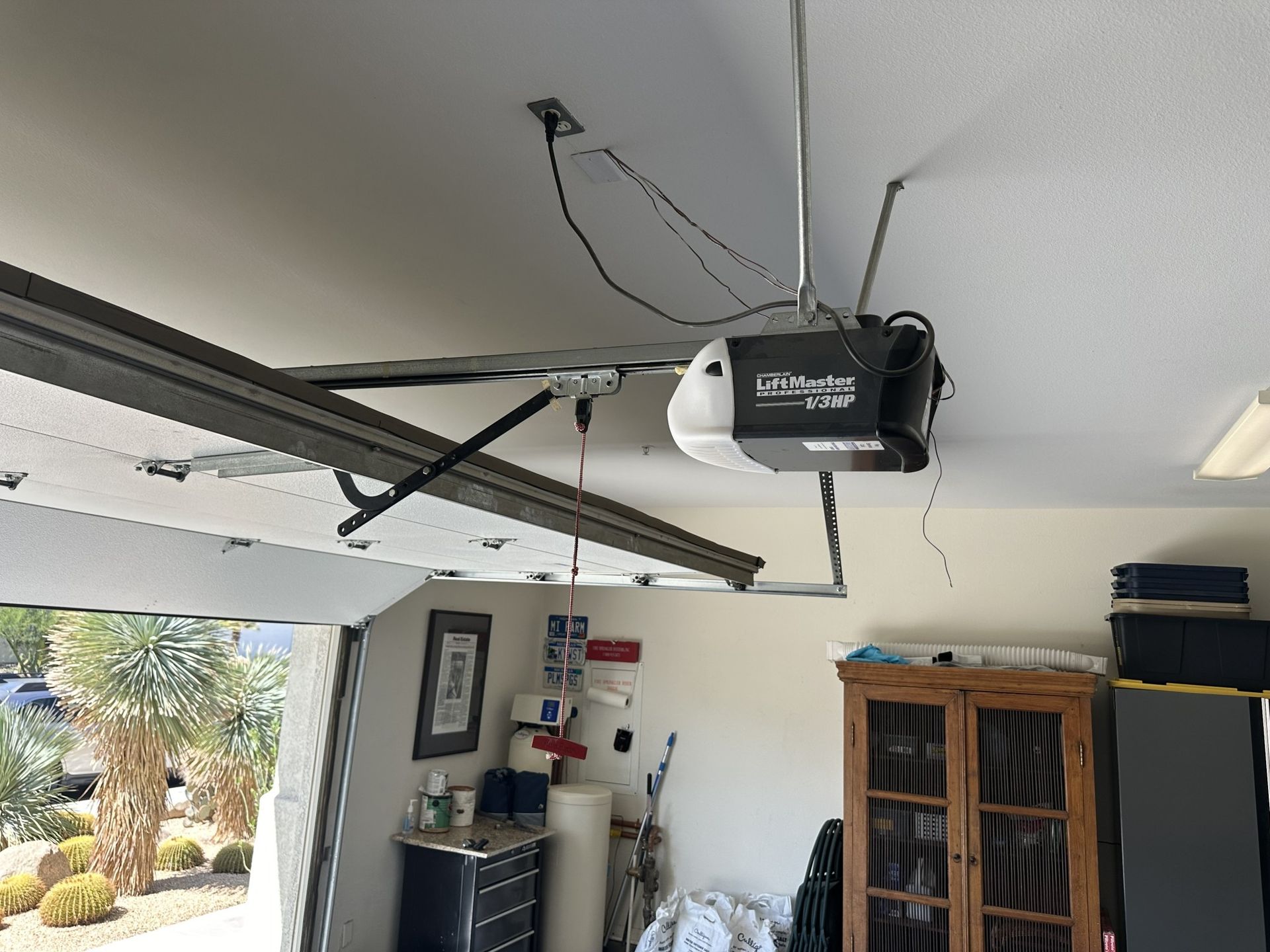 A garage door opener is hanging from the ceiling in a garage.