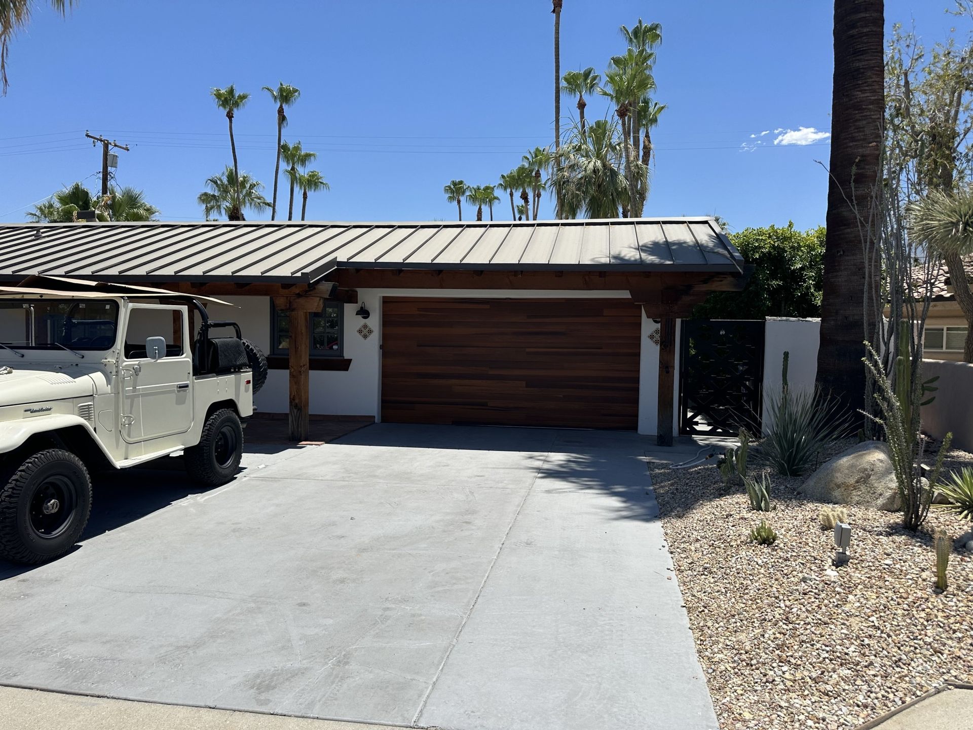 A white jeep is parked in front of a house