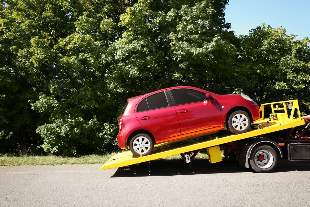 Red Hatchback on a Yellow Tow Truck Ramp — Auto Maniac in Cape Tribulation, QLD