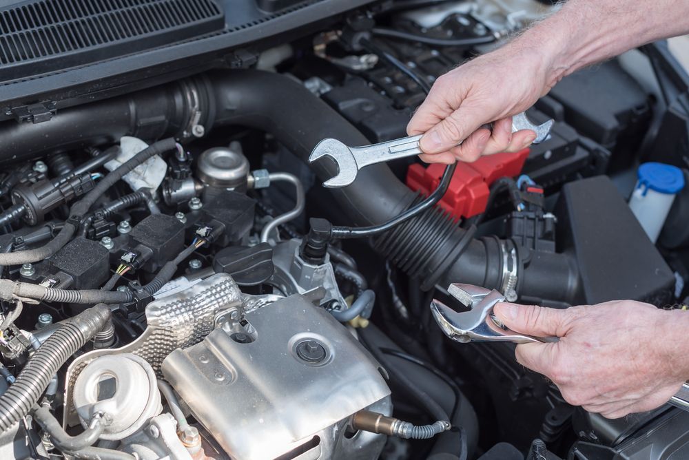 Hands Using a Wrench to Work on a Car Engine — Auto Maniac in Port Douglas, QLD
