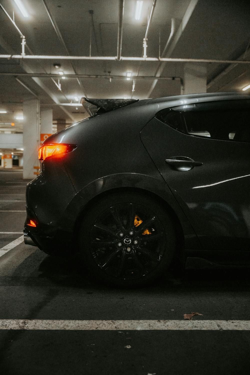 A Black Car Is Parked In A Parking Garage At Night — Auto Maniac in Mossman, QLD