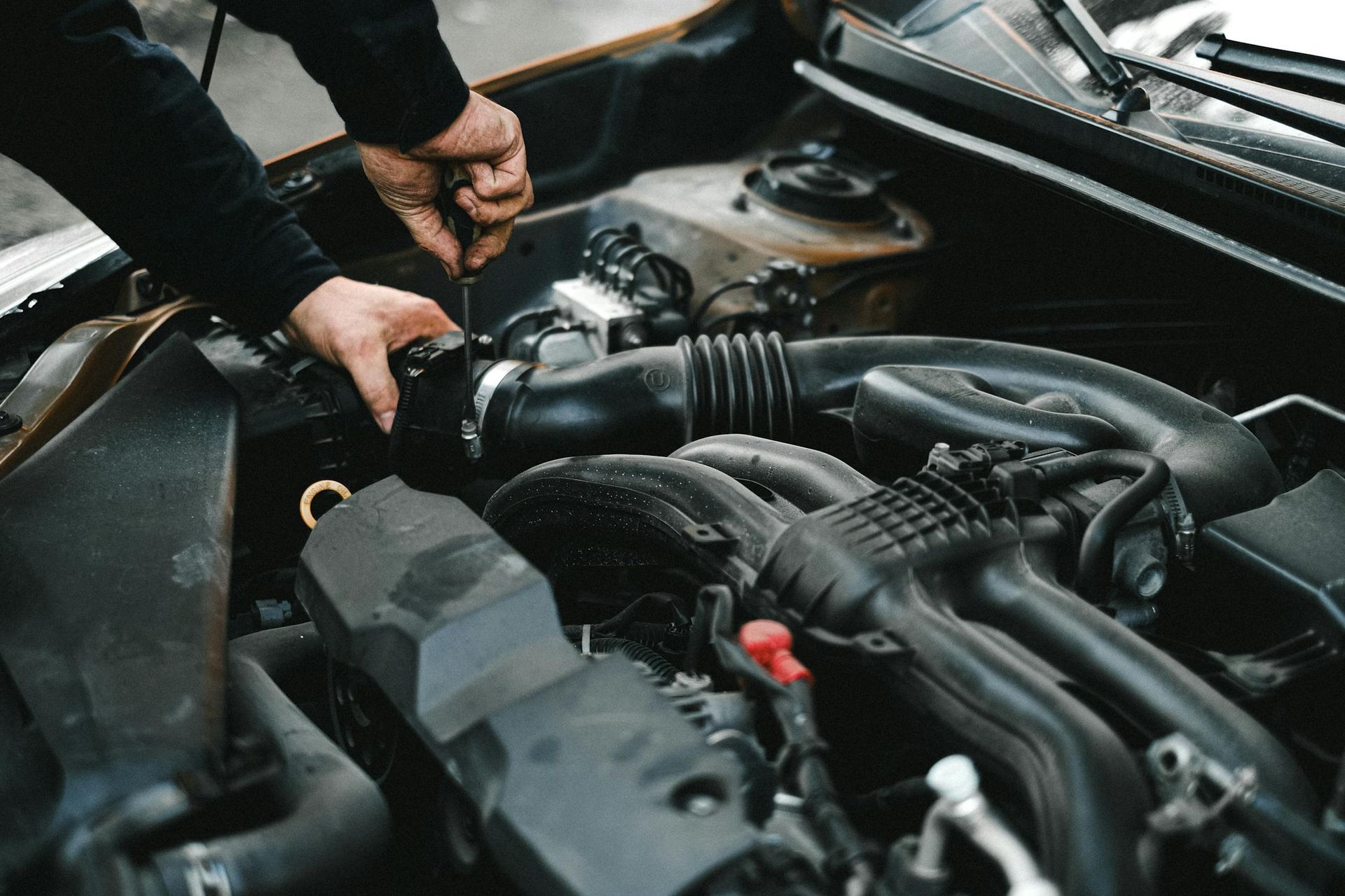 A Man Is Working On The Engine Of A Car — Auto Maniac in Mossman, QLD