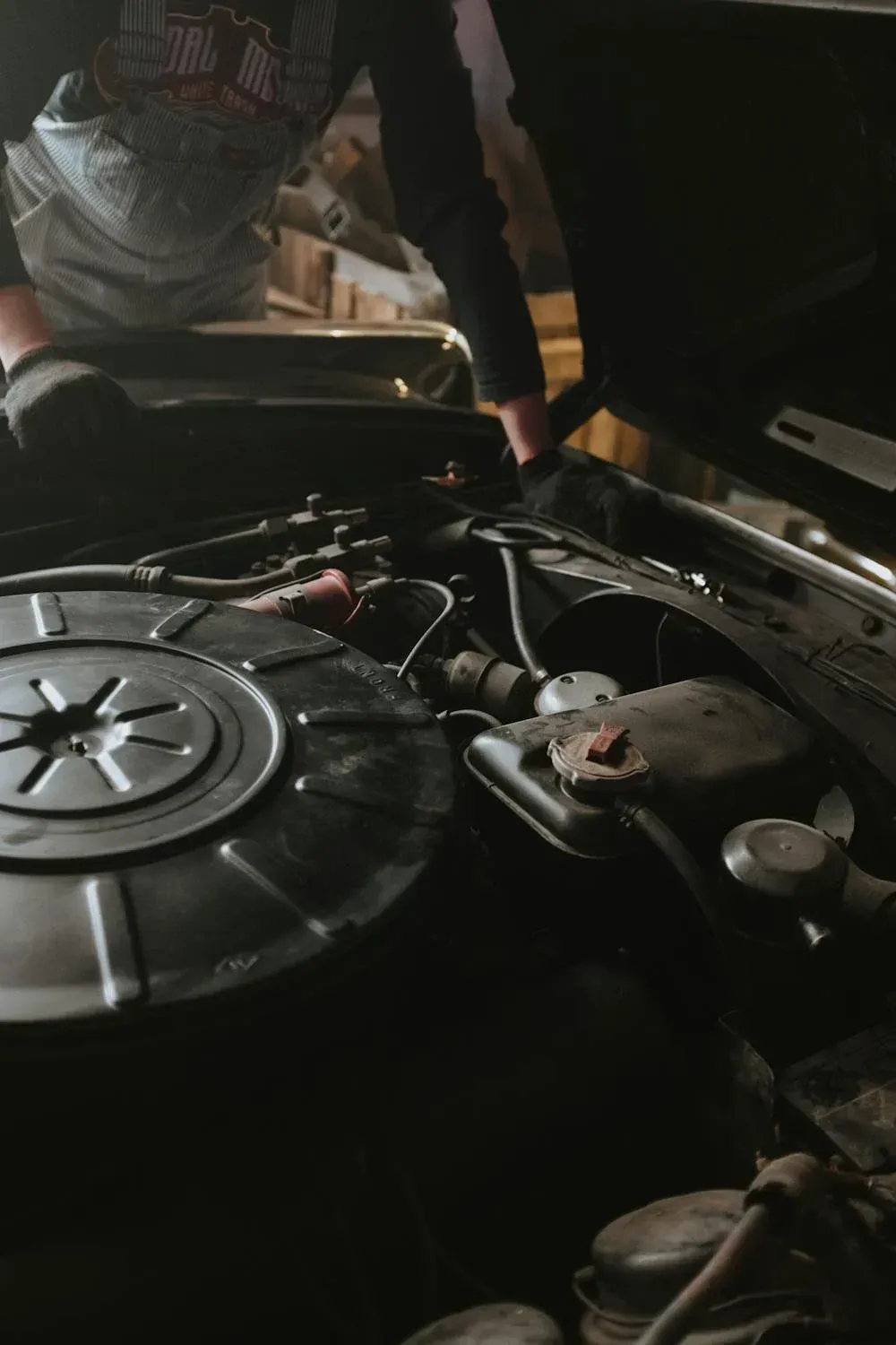 A Man Is Looking Under The Hood Of A Car — Auto Maniac in Mossman, QLD