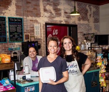 Three women are posing for a picture in a restaurant.