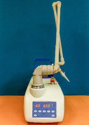 A machine is sitting on a table in front of a blue wall.