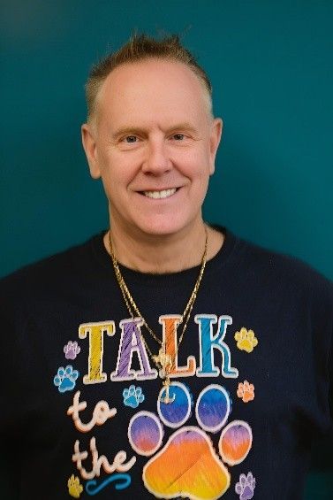 A man wearing a shirt that says talk to the dog