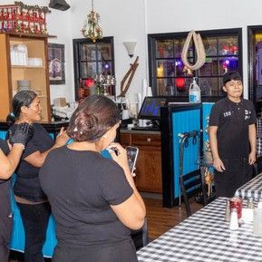 A group of people are standing around a table in a restaurant.