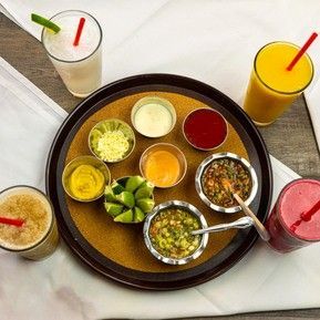 A tray with a variety of sauces and smoothies on it