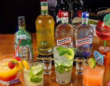 A table topped with a variety of drinks and bottles of alcohol.