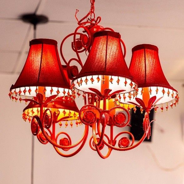 A chandelier with red shades is hanging from the ceiling