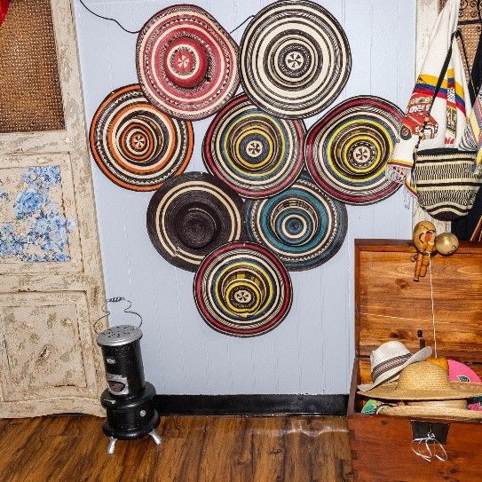 A bunch of hats are hanging on a wall in a room