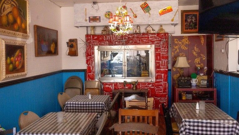 A restaurant with tables and chairs and a chandelier hanging from the ceiling.