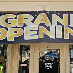 A store front with a sign that says `` grand opening ''.