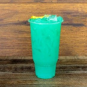 A blue drink in a plastic cup on a wooden table.
