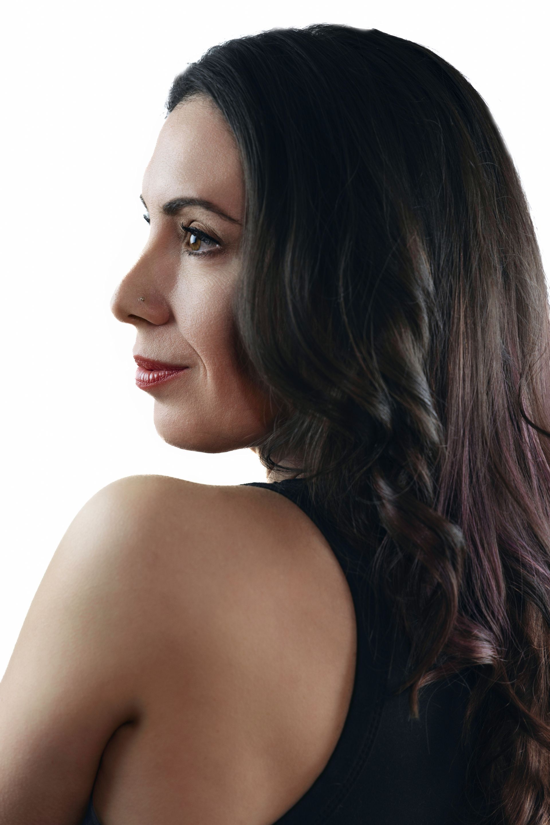 A woman in a long red dress is standing on a white background.
