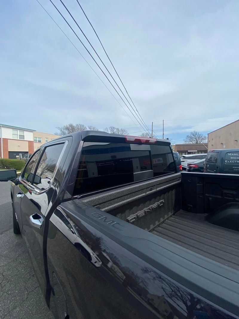 A black truck is parked on the side of the road.