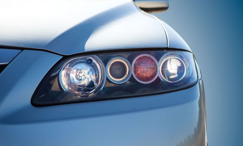 A close up of a car 's headlights on a blue background.