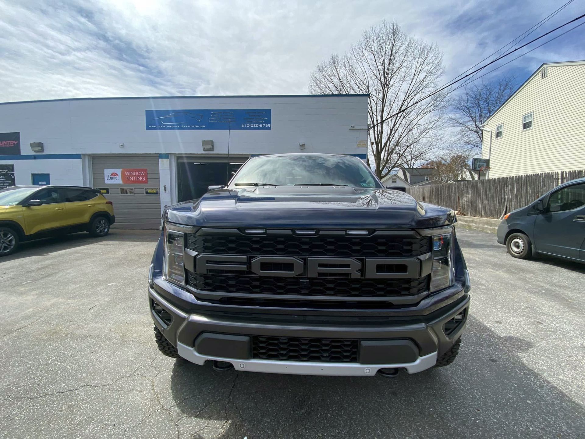 A ford truck is parked in front of a building.
