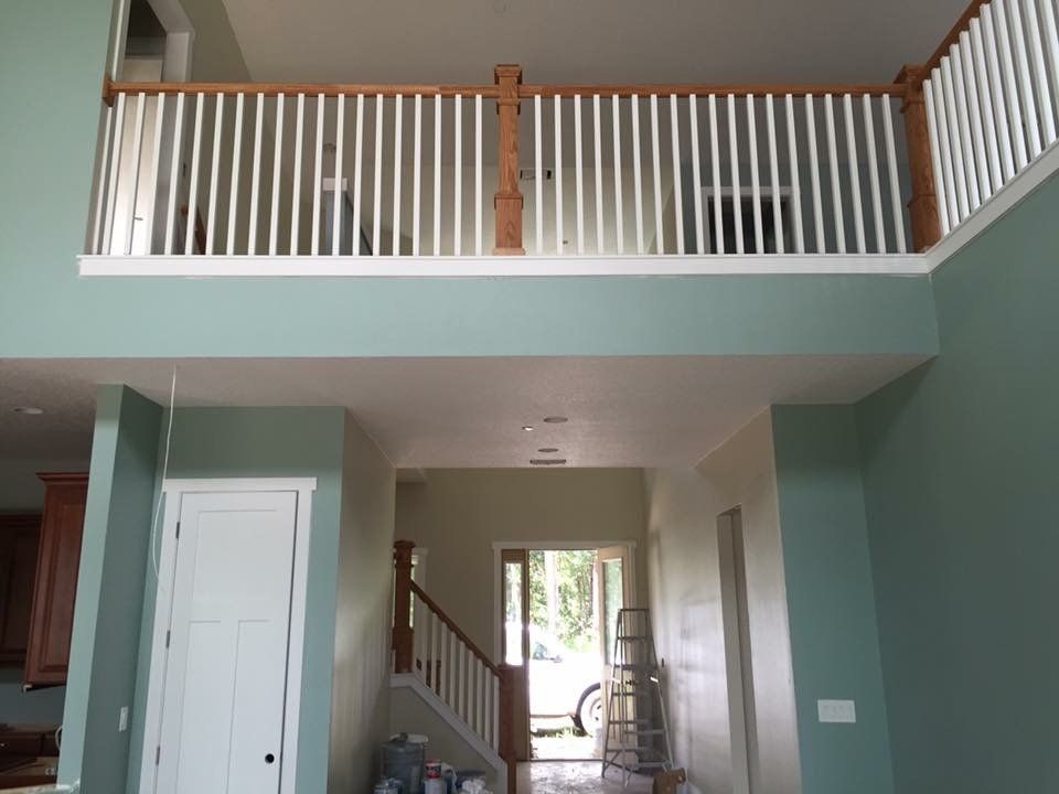 Interior view of a house with a balcony and white railing painted in turquoise.