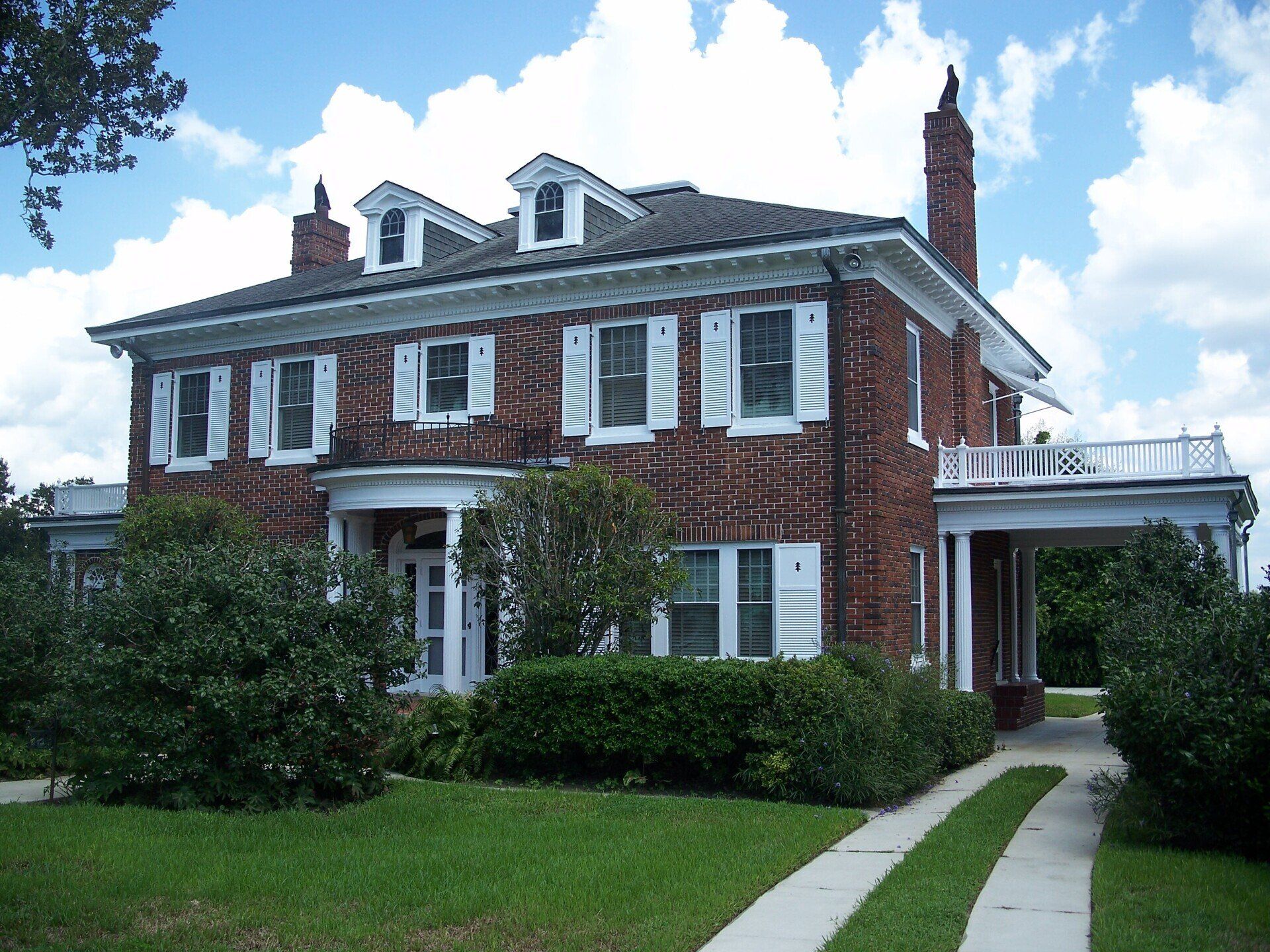 A large brick house with white shutters on the windows
