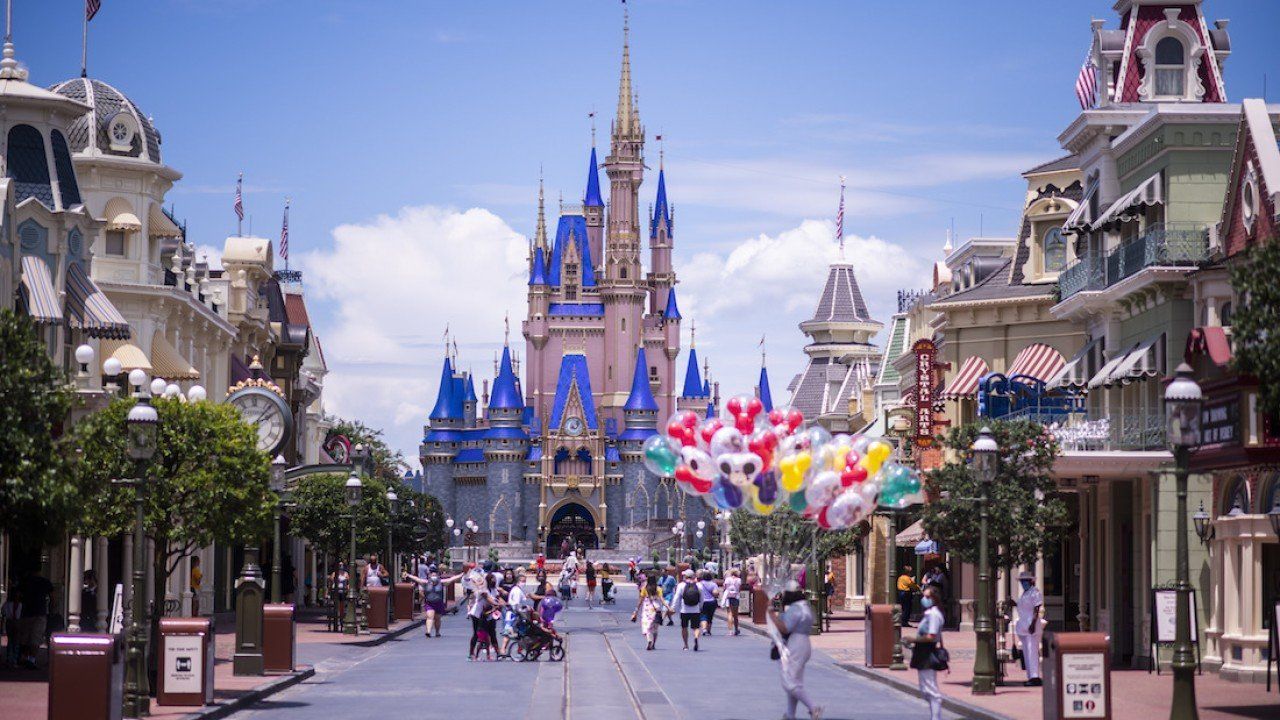A group of people are walking down a street in front of a castle.