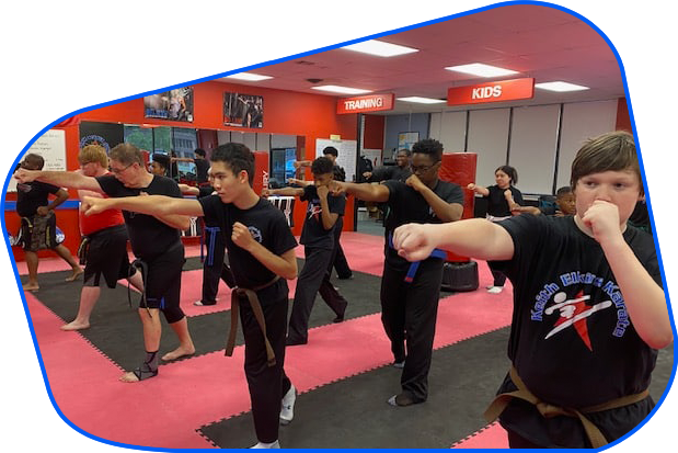 A group of young men are practicing martial arts in a gym