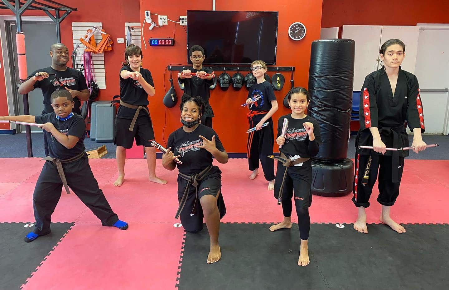 A group of young people are practicing martial arts in a gym.