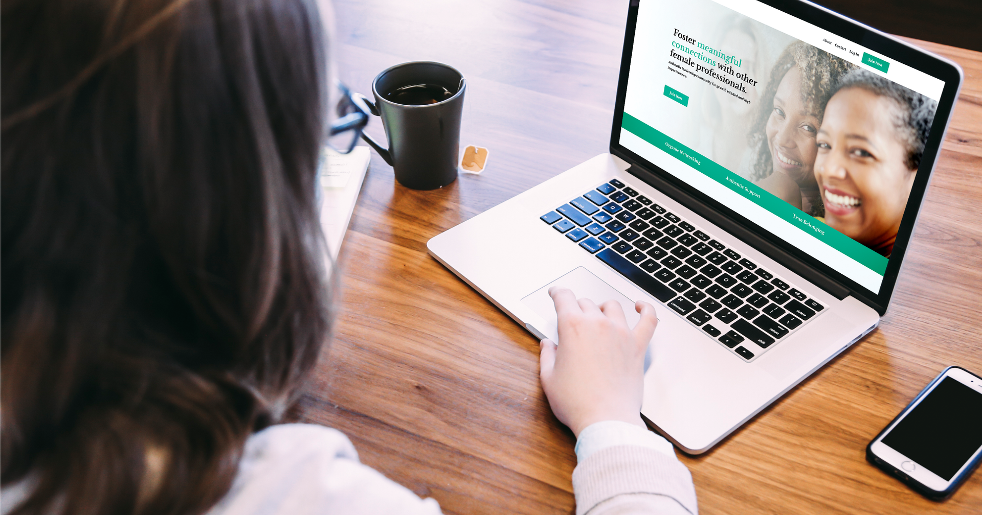 woman using laptop on desk with coaching website on the screen
