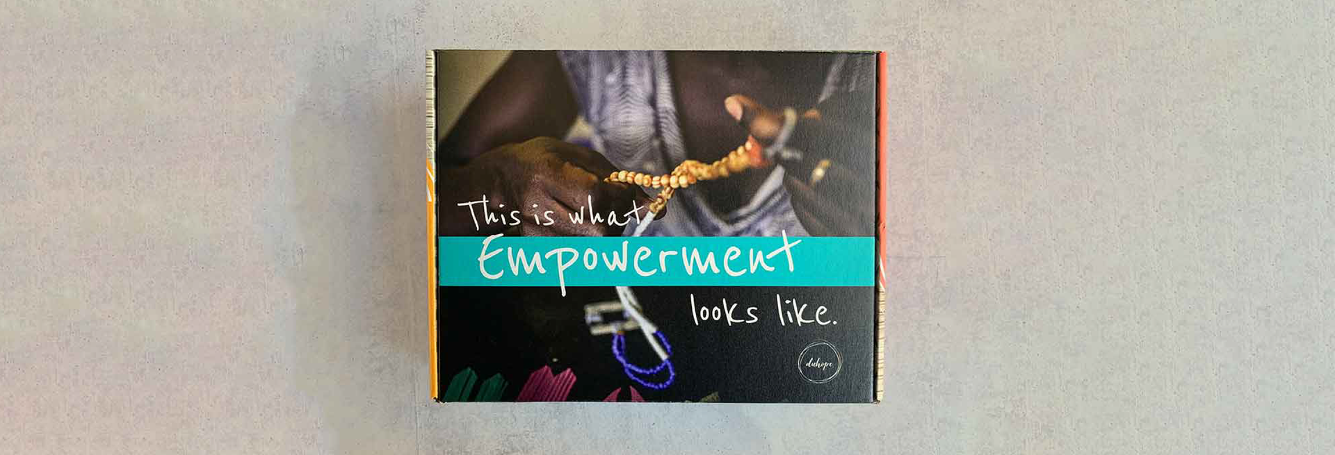 display box with dark skinned hands holding jewlery