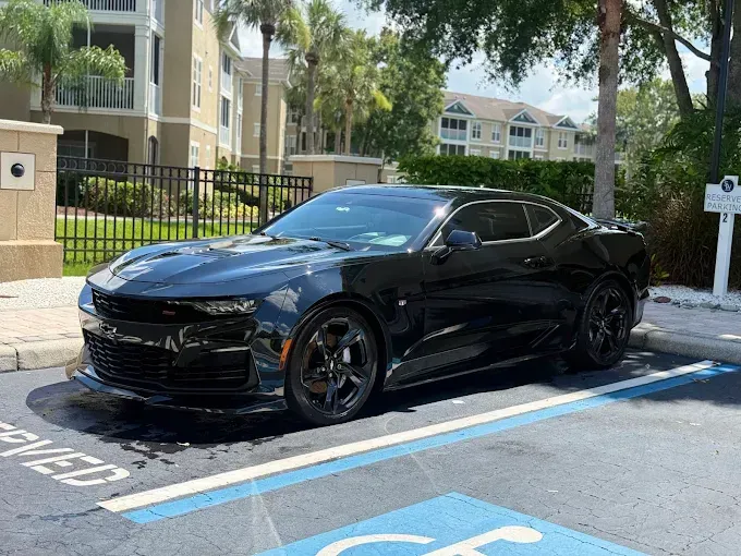 Black Chevrolet Camaro parked in a reserved space.