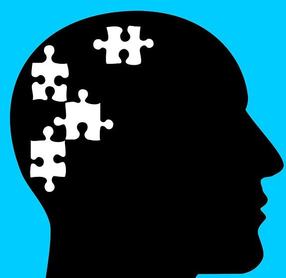 a silhouette of a head with puzzle pieces coming out of it