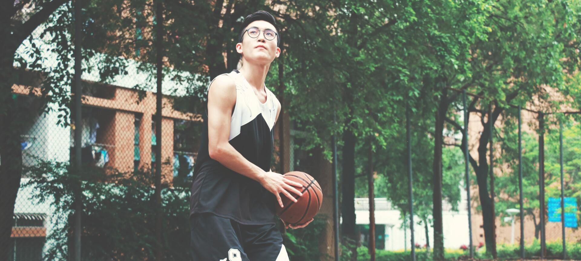 man with glasses playing basketball
