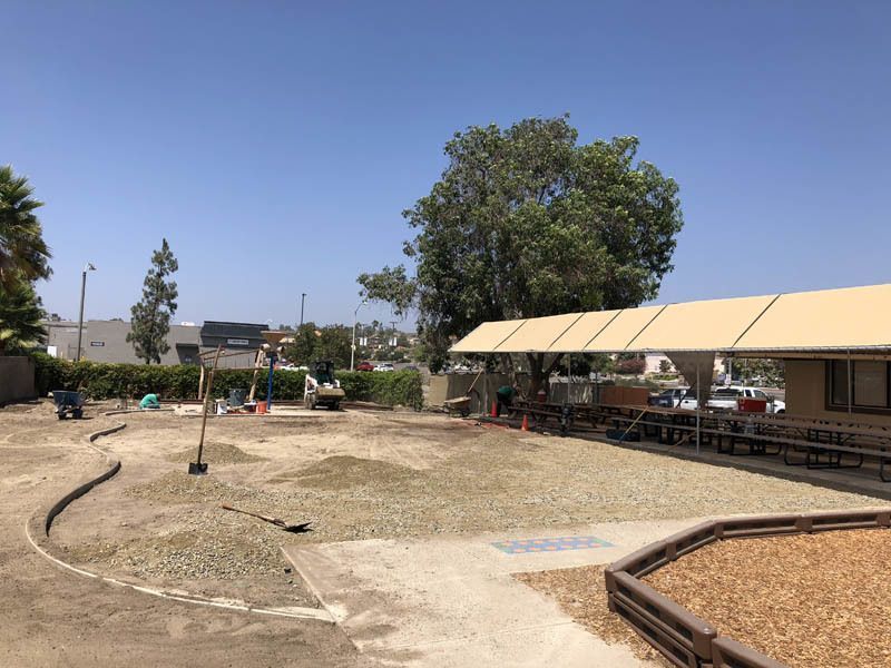 A large yard with a covered area and a picnic table