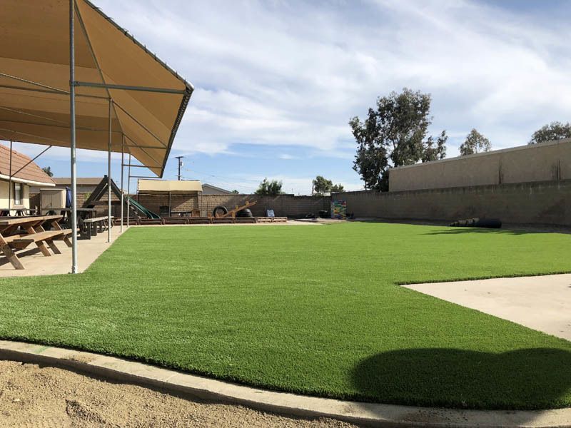 A large lawn with a picnic table under a canopy
