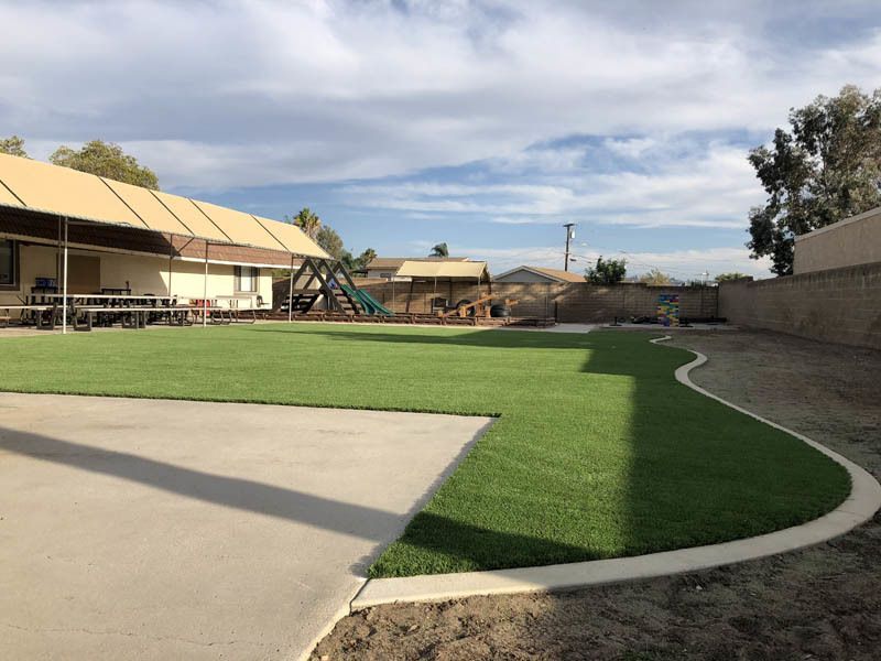 A large lawn with a playground in the background