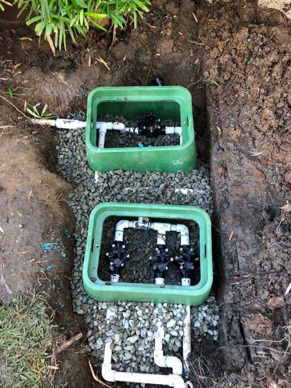 A couple of green boxes sitting on top of a pile of gravel