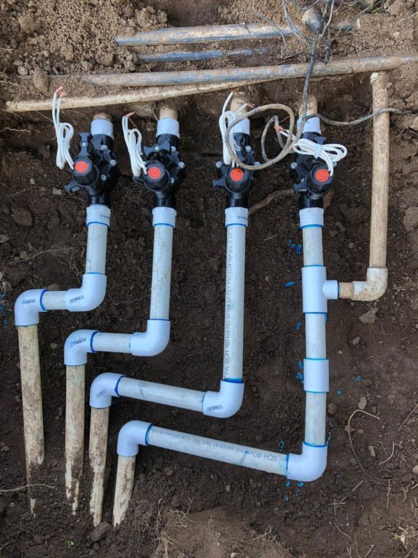 A bunch of pipes are connected to each other in the dirt