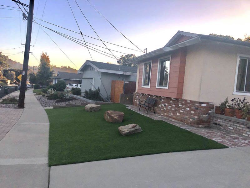 A house with a lush green lawn in front of it