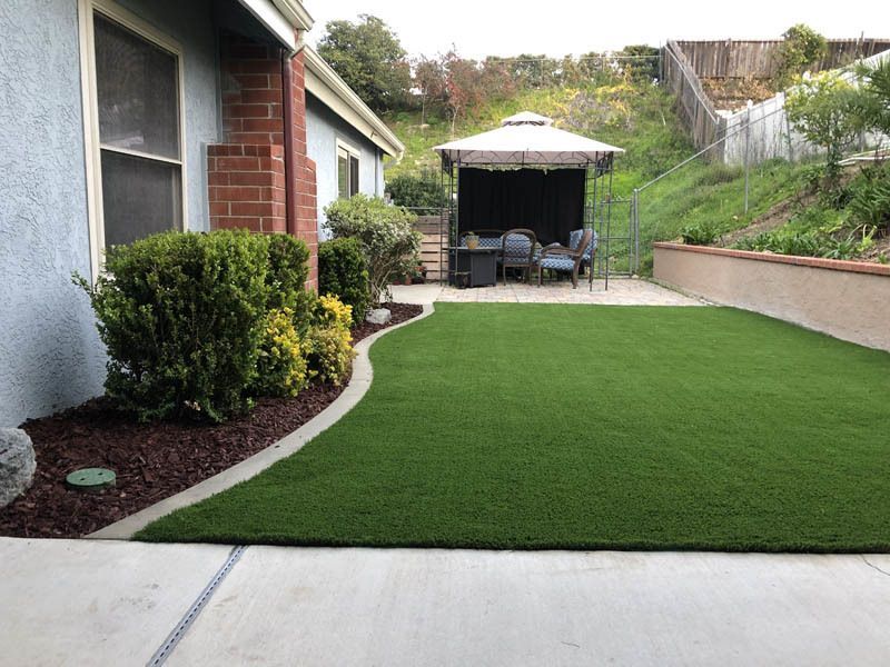 A lawn with a gazebo in the backyard of a house