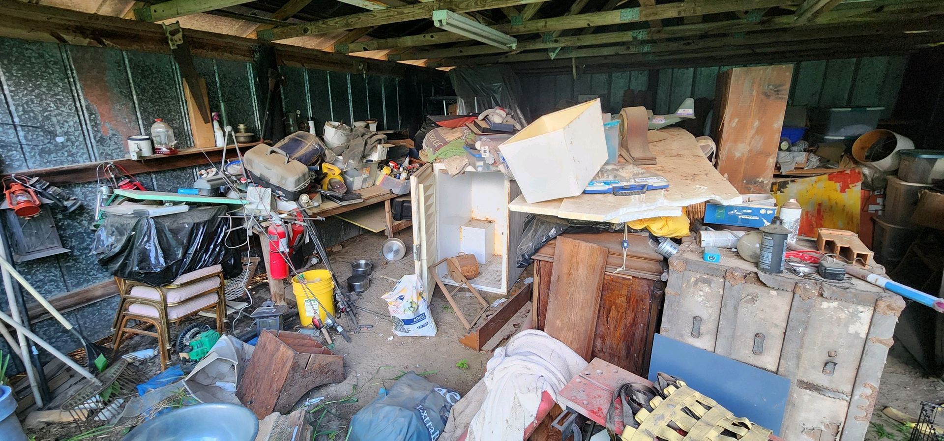 A cluttered storage area with various objects.  Debris, boxes, and other items fill the space.