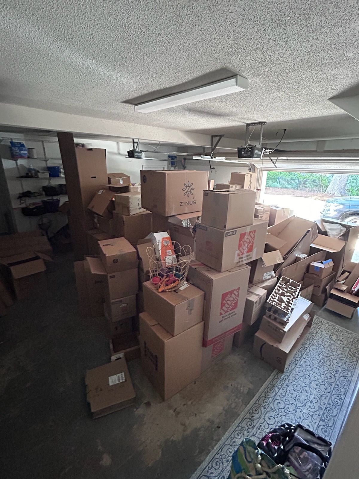 Garage filled with numerous cardboard boxes, possibly during a move or storage.