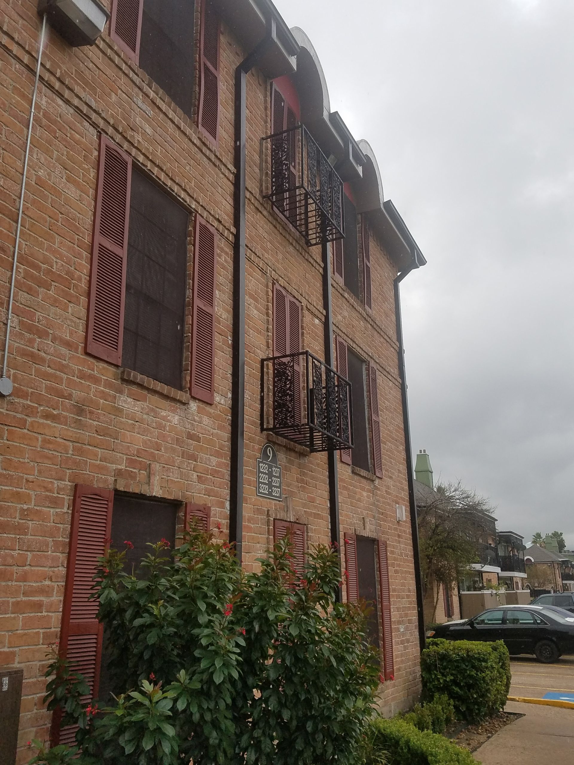 A brick building with red shutters and a fire escape