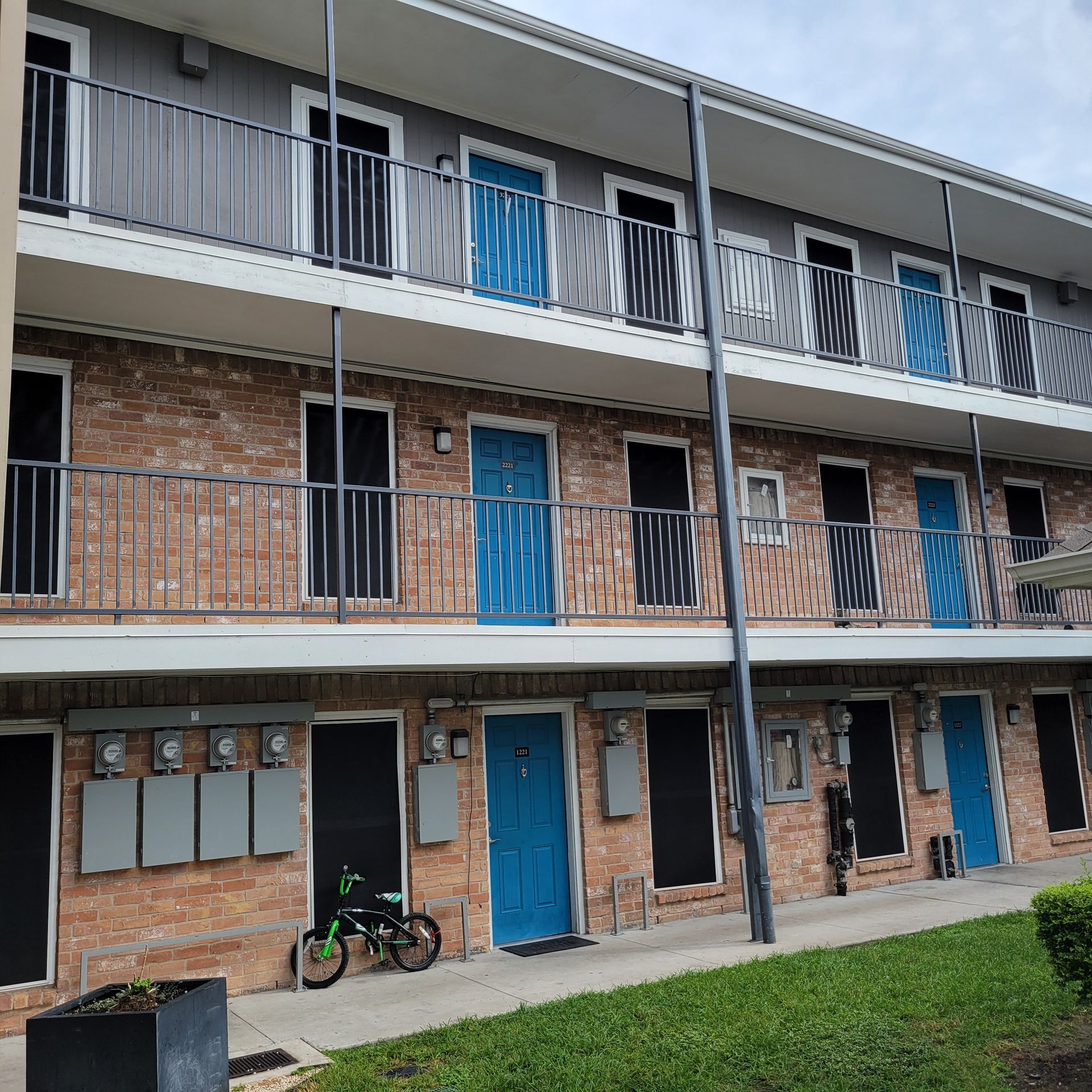 A bicycle is parked in front of a building with blue doors