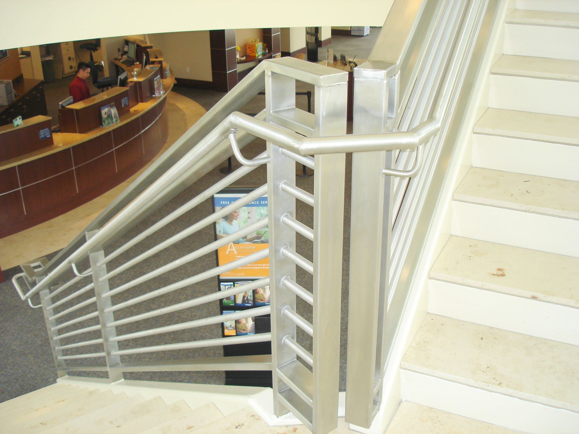 A staircase in a building with a stainless steel railing
