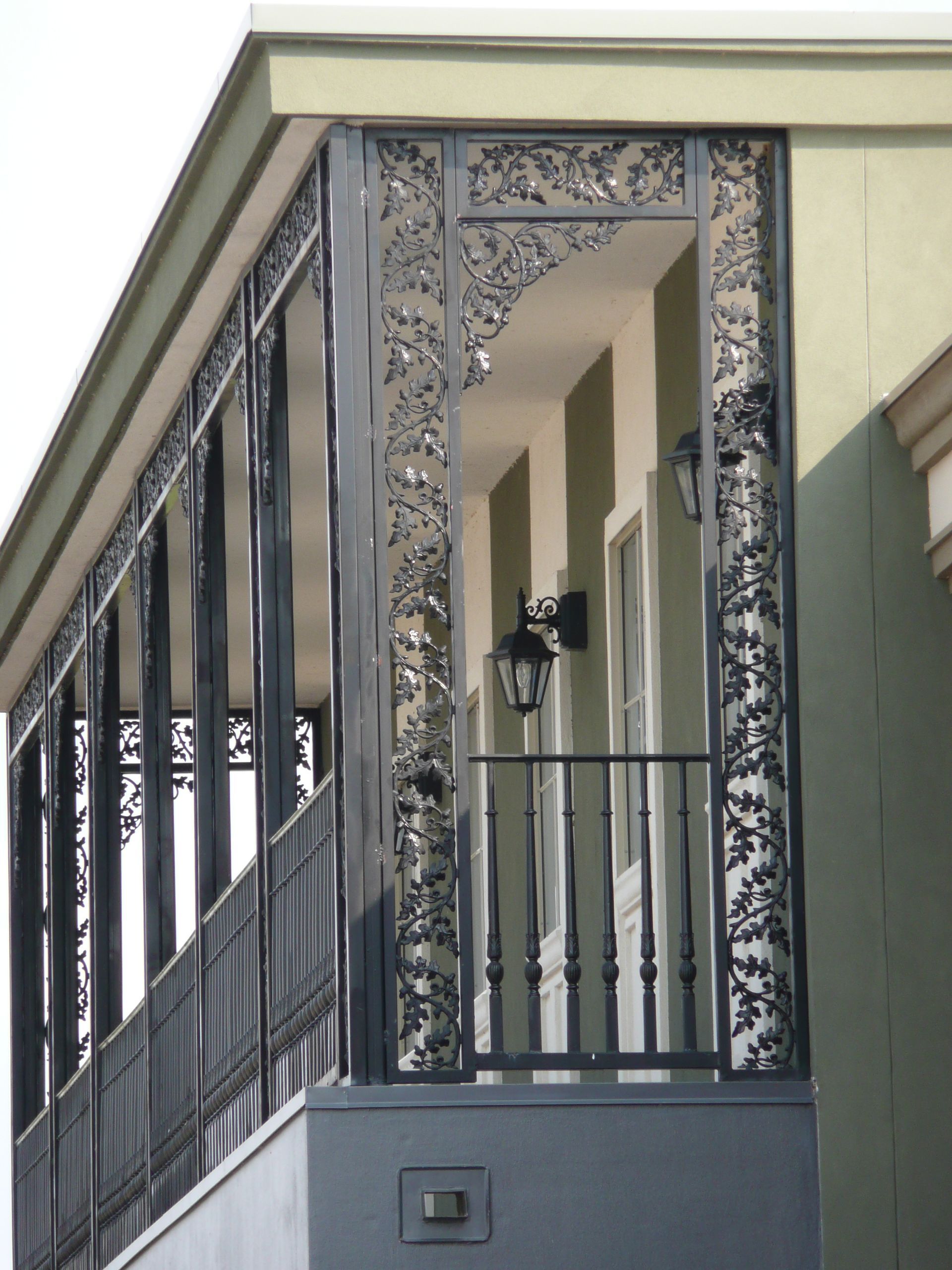 A balcony on the side of a building with a wrought iron railing