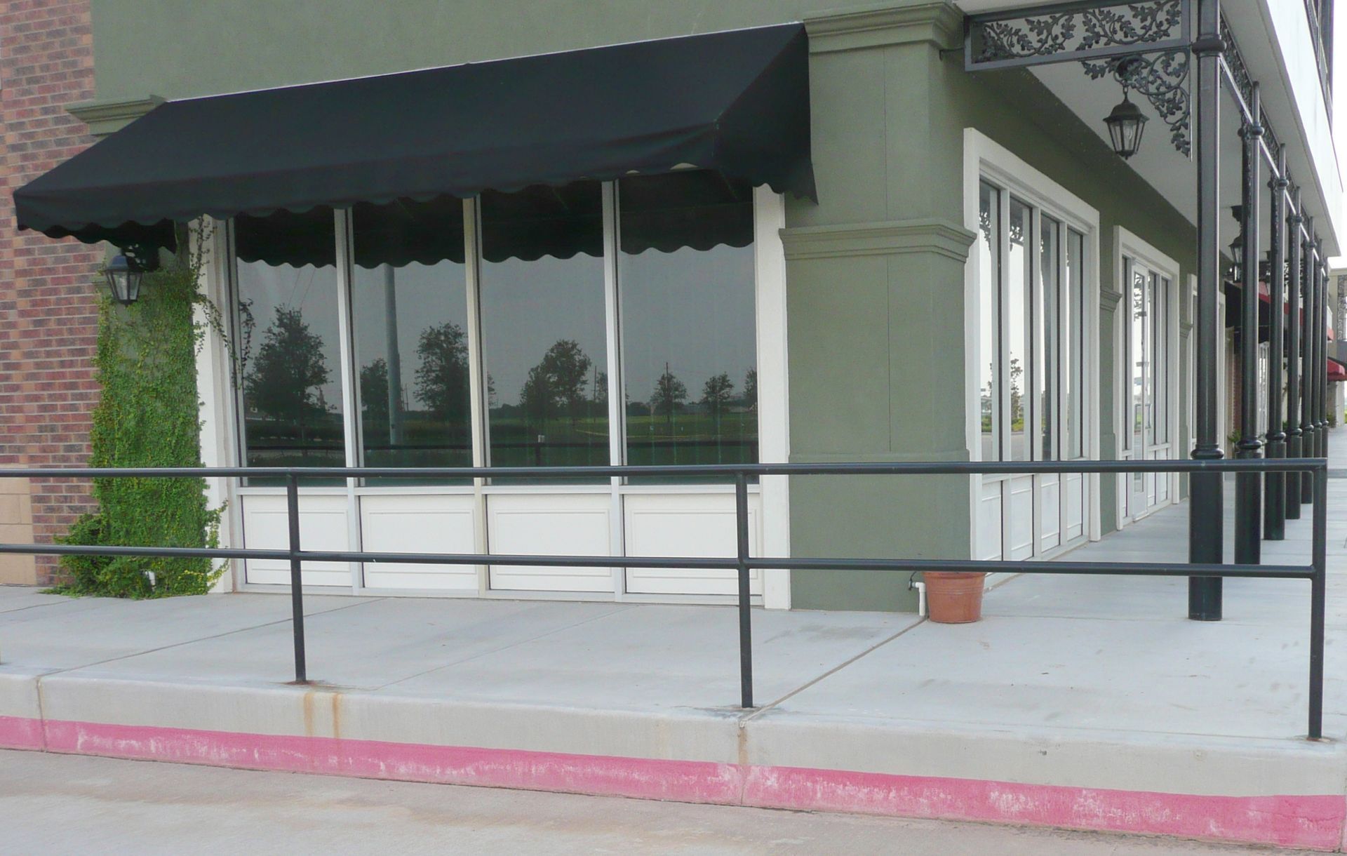 A store front with a black awning and a railing