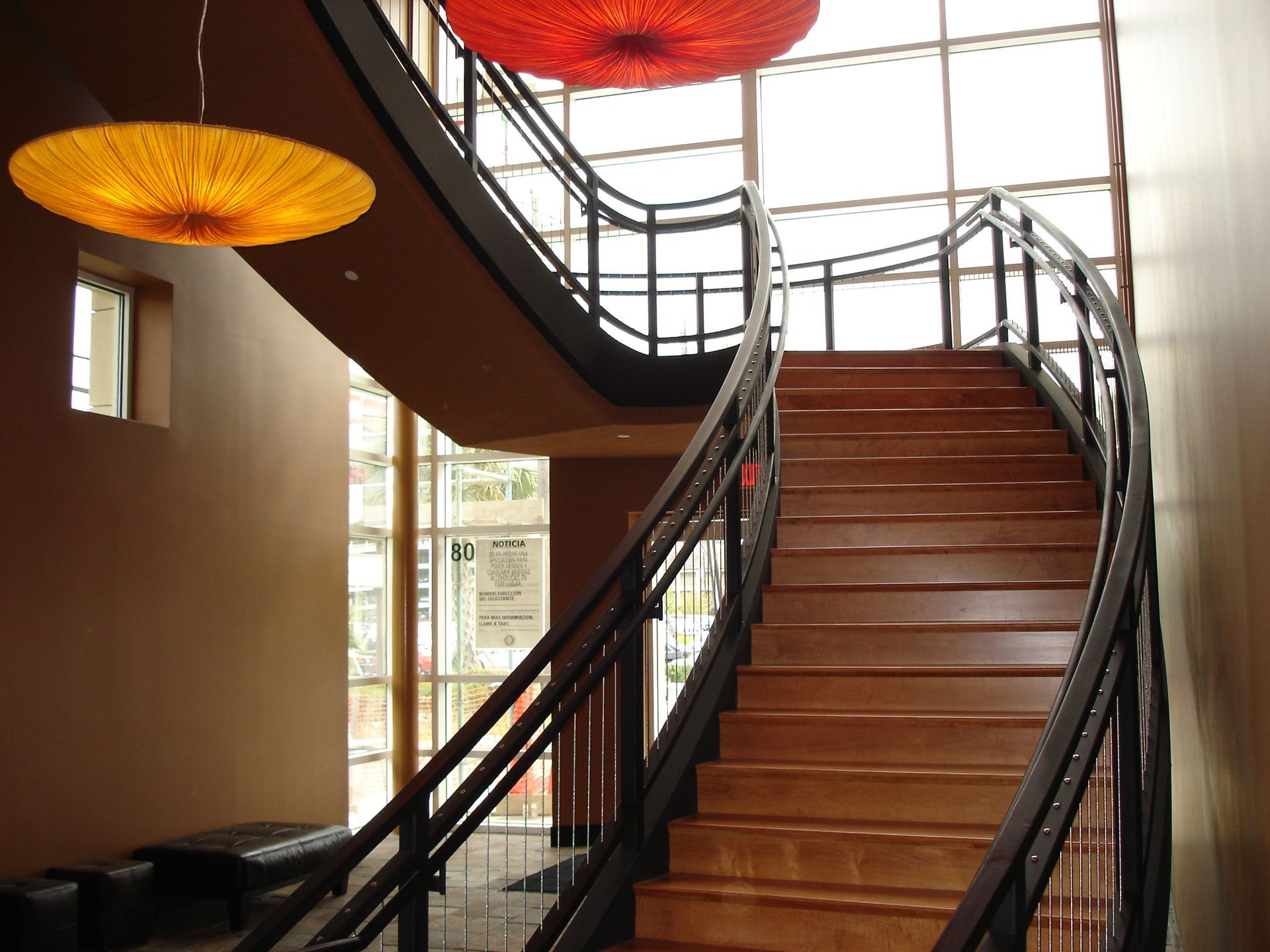 A wooden staircase with a metal railing in a building